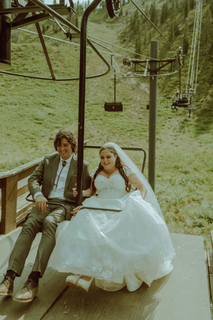 bride and groom in wedding dress on ski lift in Oregon at ski bowl mt hood destination wedding