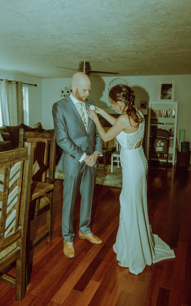 bride helping groom get ready at bend oregon wedding