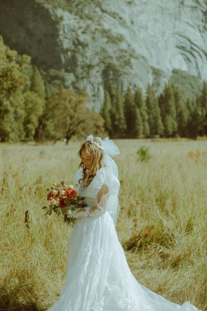 bride posing in vintage thrifted dress for destination elopement in yosemite national park california