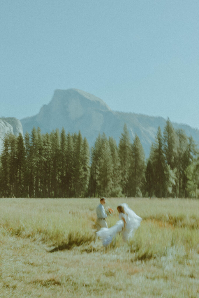 couple running in half dome meadown at yosemite national park for their deestination elopement 