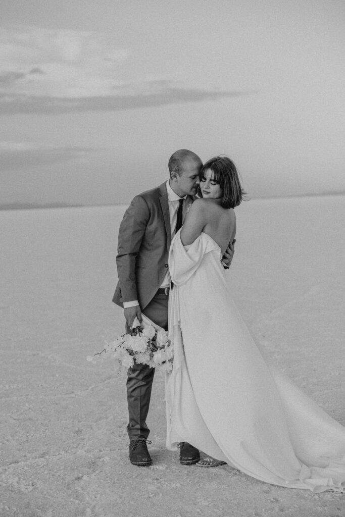 black and white photo of groom and bride at destination elopement at the salt flats in utah 