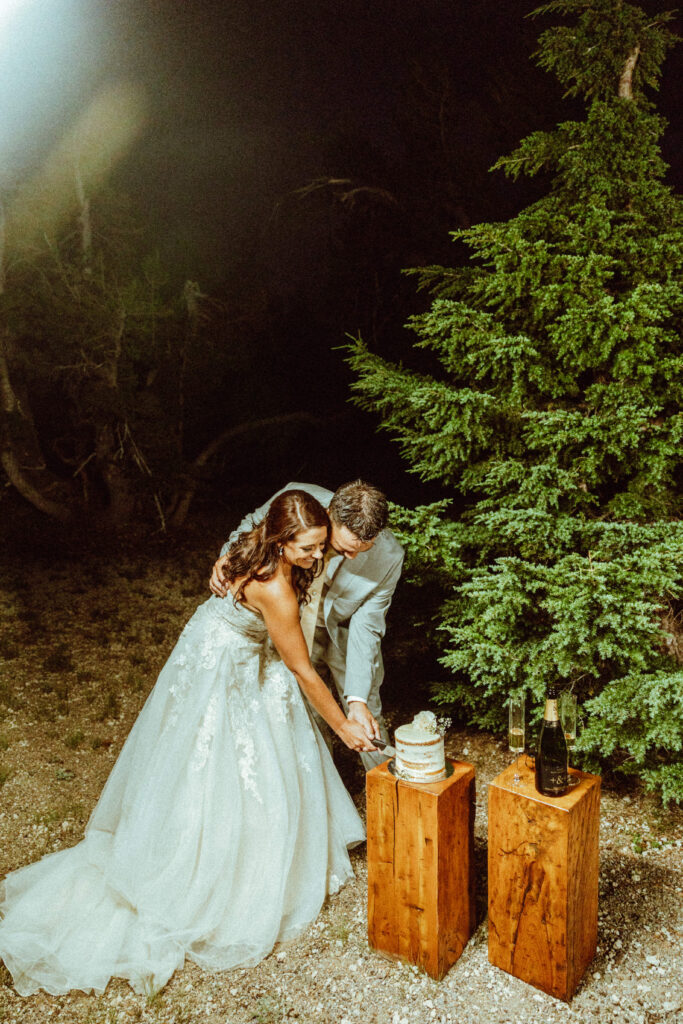 bride and groom cut cake at crater lake national park elopement 