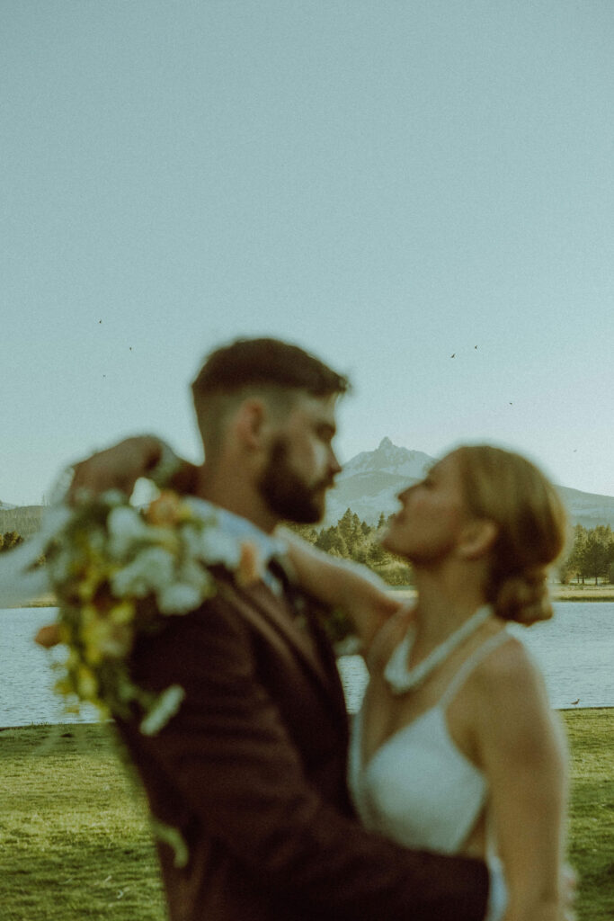 bride and groom kissing at wedding in front of cascade mountain range in bend oregon 