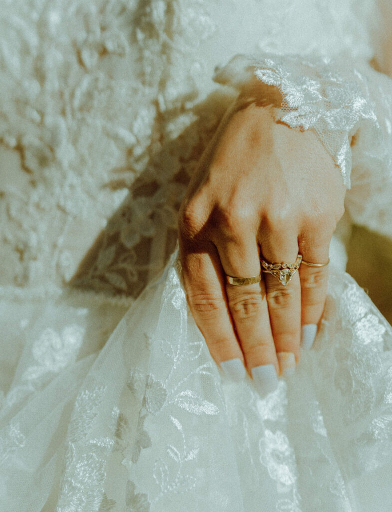 wedding ring on bride holding dress