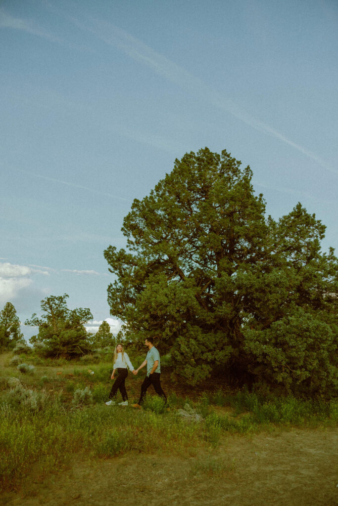 girl and boy walking for engagement photos in oregon badlands