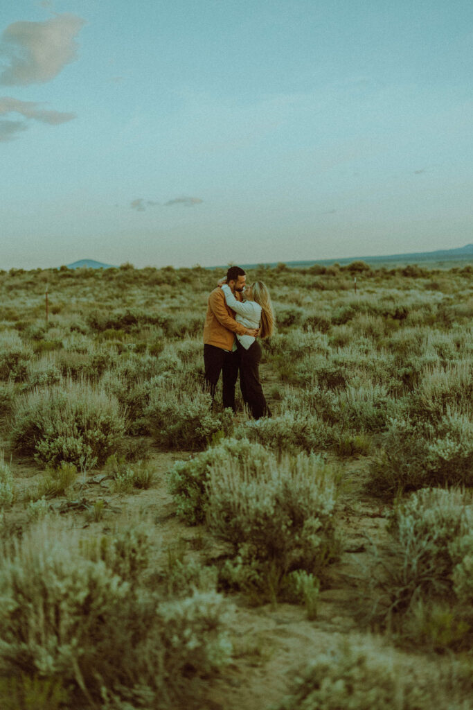 bride and groom posing in a field of sagebrush for oregon badlands engagement session