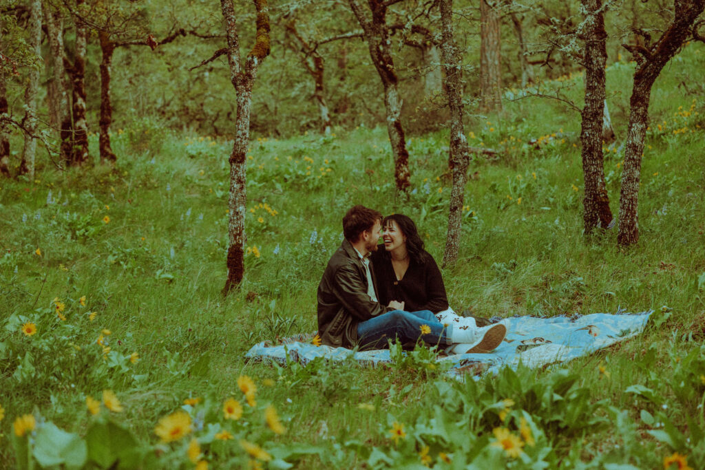 couple on a blanket at their oregon engagement session in the gorge