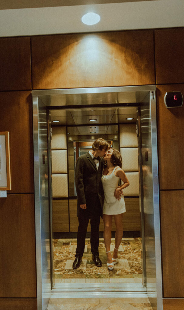 bride and groom kissing in an elevator in oxford hotel in bend oregon for their engagement photos