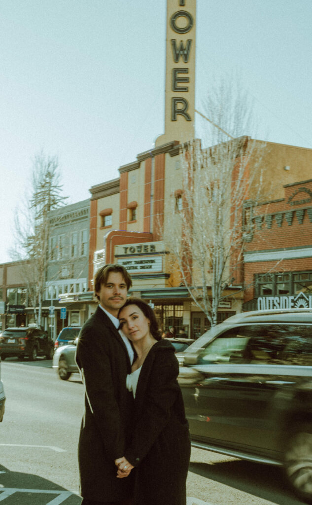 couple holding eachother in front of theater sign in bend oregon