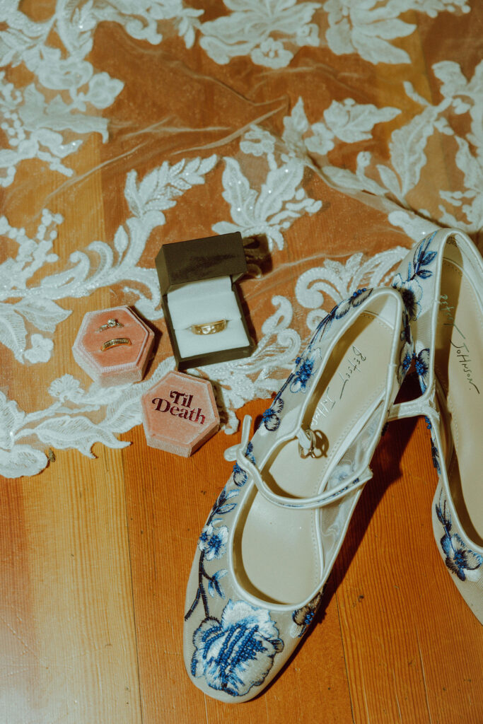 flat lay of brides rings veil and shoes