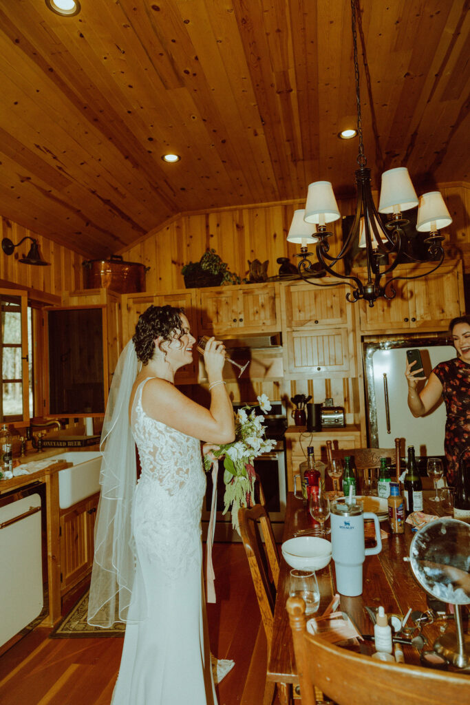 bride drinking champagne on morning of wedding 