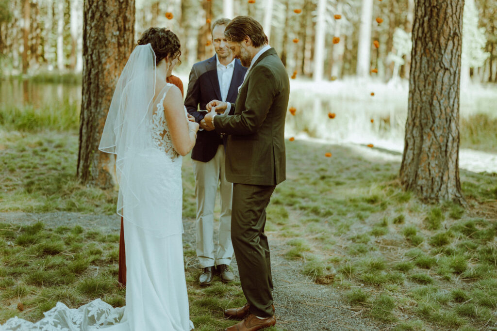 groom putting on ring at wedding ceremony