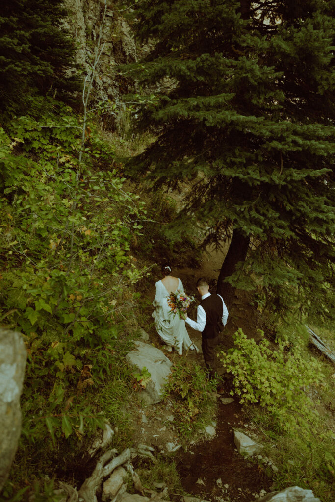 bride and groom walking in the forest on their wedding day 