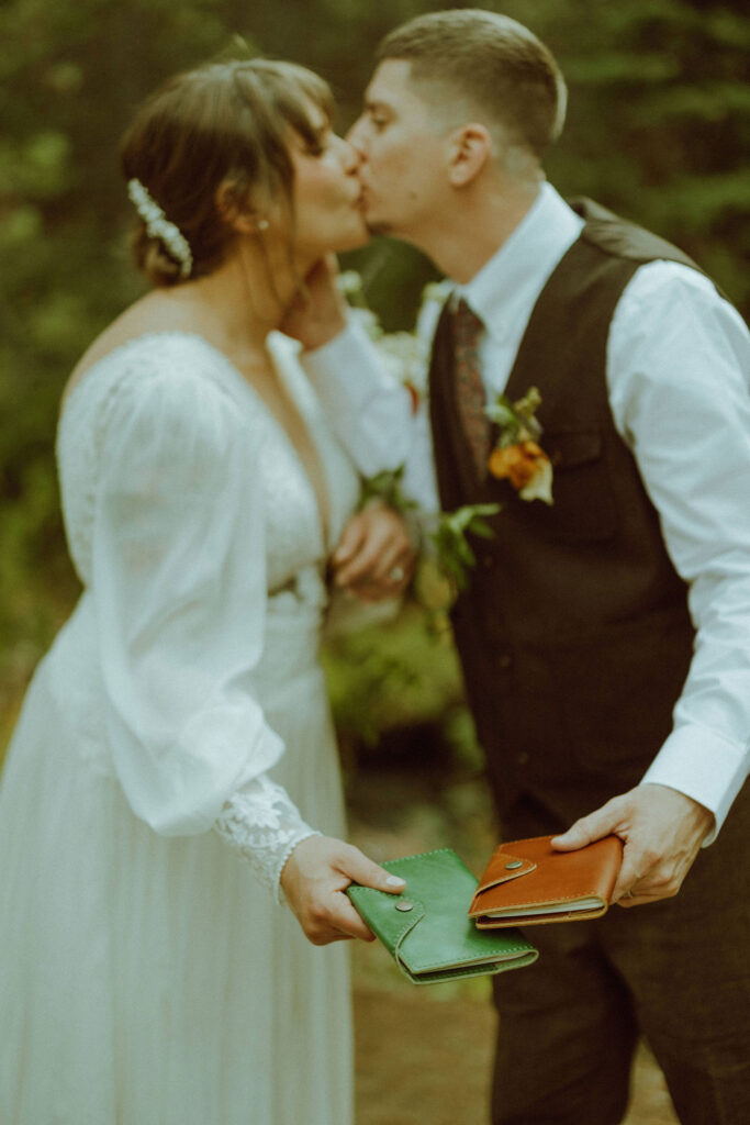 bride and groom kiss in the forest