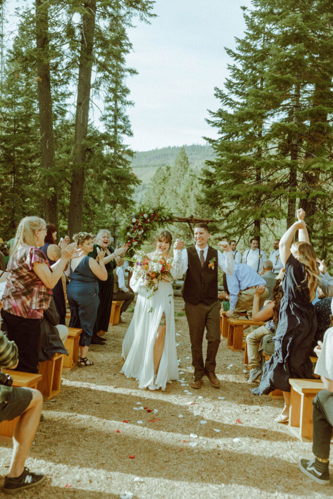 bride and groom walking down aisle at skyliner lodge wedding venue 