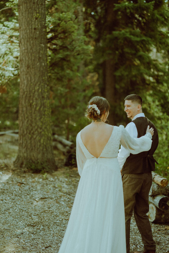 bride and groom first look at skyliner lodge wedding in the forest bend oregon