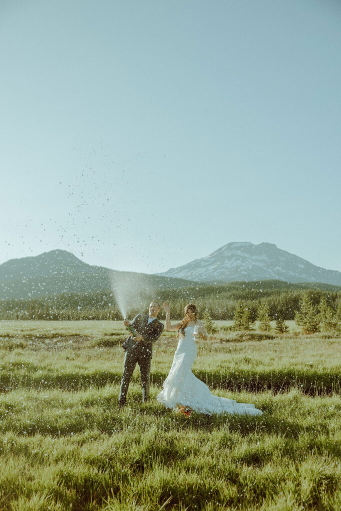 sparks lake oregon elopement bride and groom spray champagne 