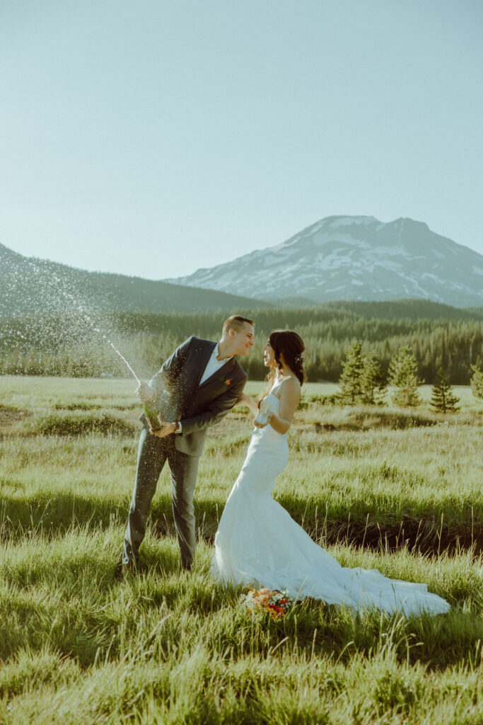 sparks lake oregon elopement bride and groom spray champagne 