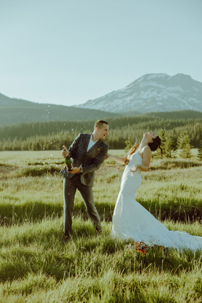 sparks lake oregon elopement bride and groom spray champagne 