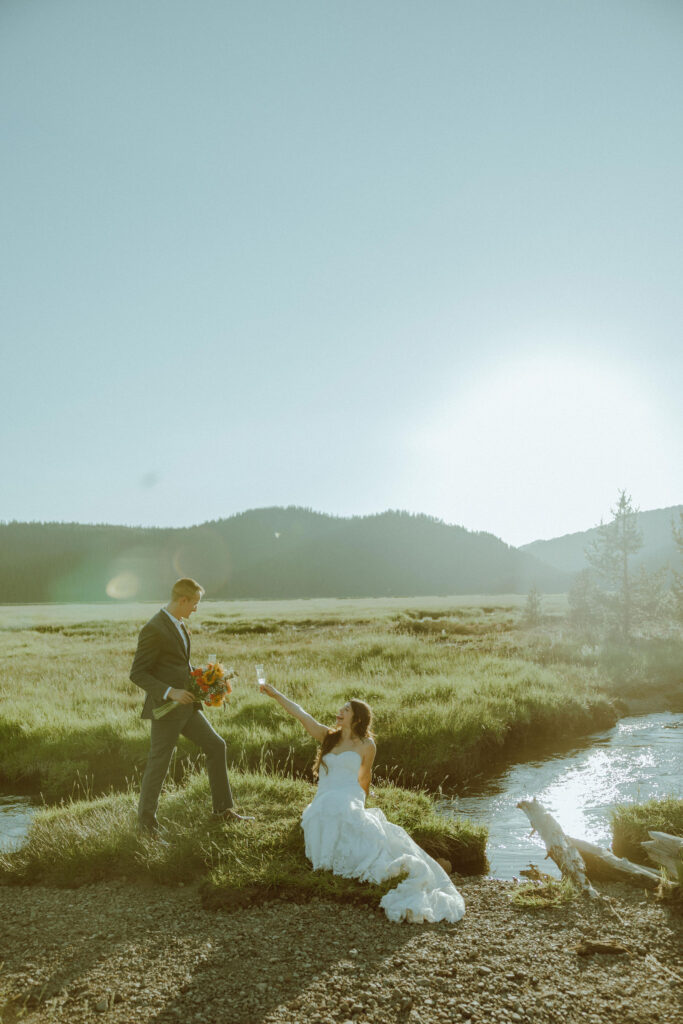  bride and groom sitting on creek bank at sparks lake oregon elopement