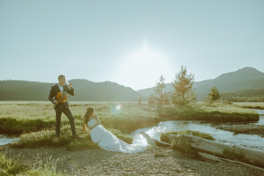  bride and groom sitting on creek bank at sparks lake oregon elopement