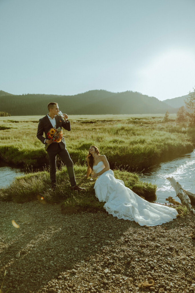  bride and groom sitting on creek bank at sparks lake oregon elopement