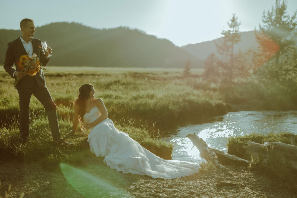  bride and groom sitting on creek bank at sparks lake oregon elopement