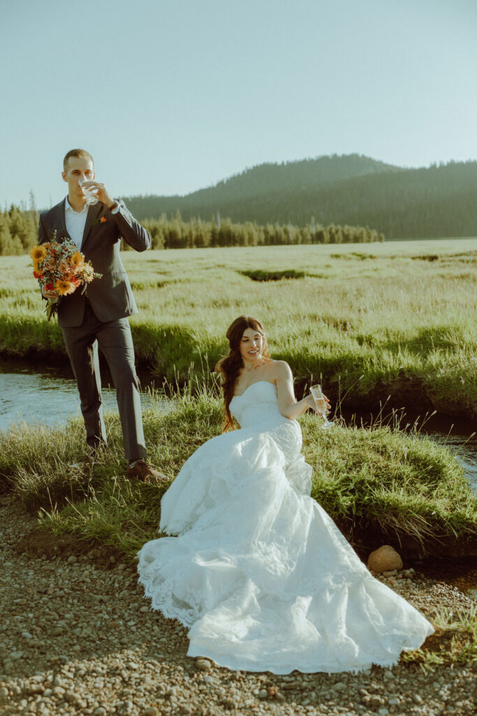  bride and groom sitting on creek bank at sparks lake oregon elopement