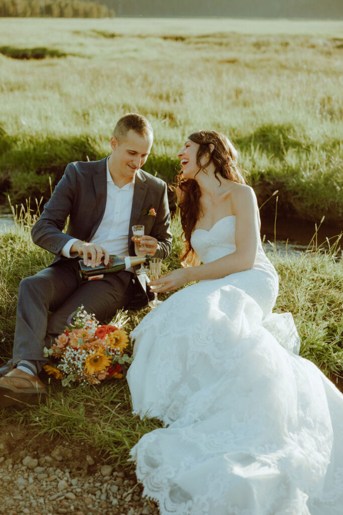  bride and groom sitting on creek bank at sparks lake oregon elopement