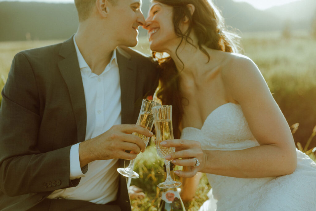 bride and groom drinking champagne at bend oregon adventure elopement at sparks lake meadow