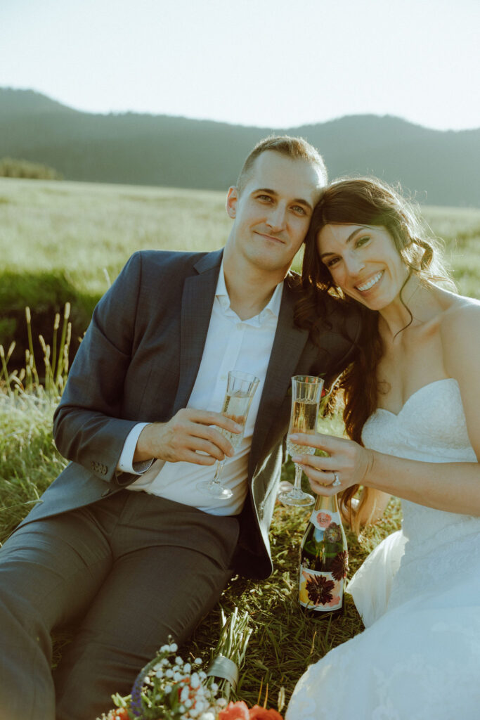 bride and groom drinking champagne at bend oregon adventure elopement at sparks lake meadow