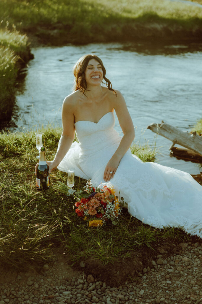  bride sitting on creek bank at sparks lake oregon elopement