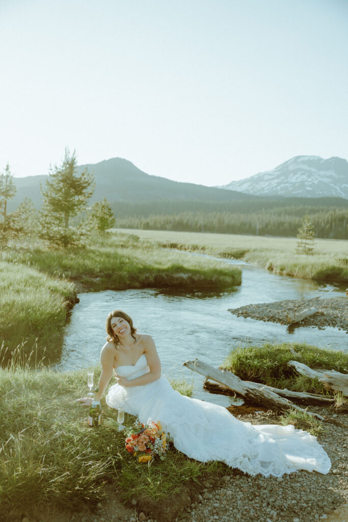  bride sitting on creek bank at sparks lake oregon elopement