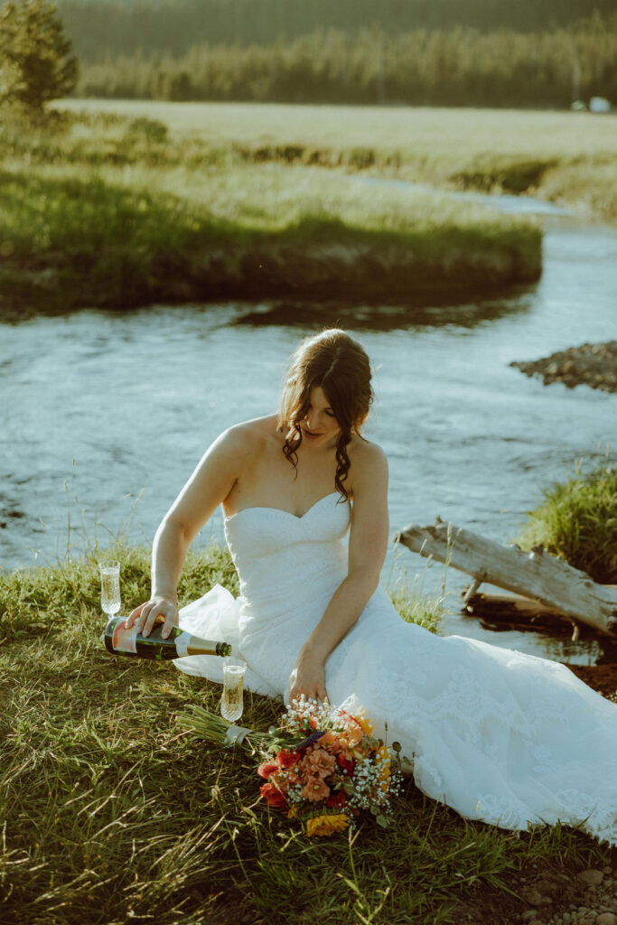  bride sitting on creek bank at sparks lake oregon elopement