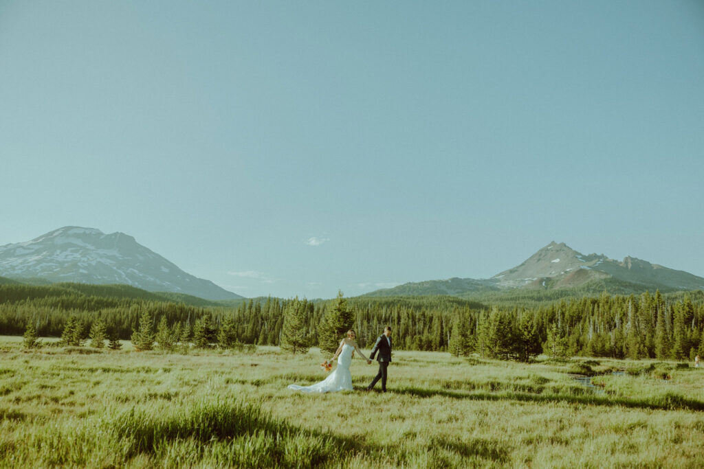 bride and groom walking in sparks lake meadow at oregon elopement 