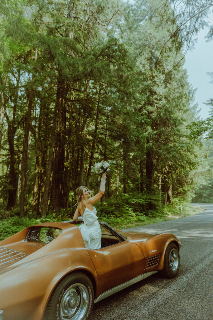 oregon bride and groom posing with a vintage car for their adventure elopement 