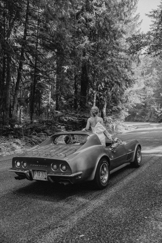 oregon bride and groom posing with a vintage car for their adventure elopement 