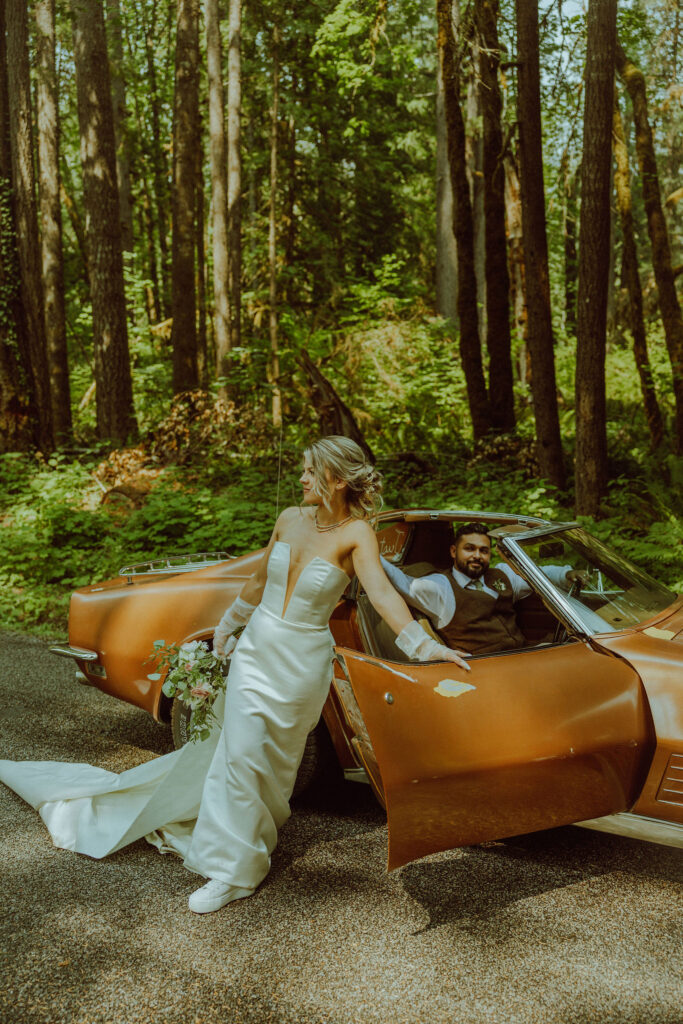 oregon bride and groom posing with a vintage car for their adventure elopement 