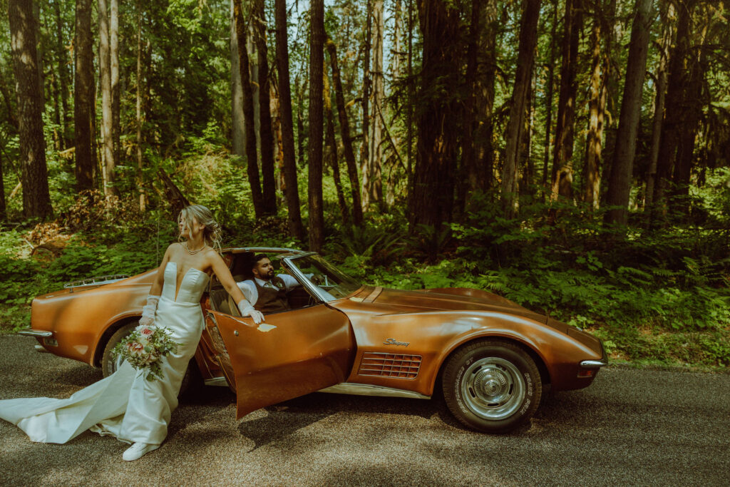 oregon bride and groom posing with a vintage car for their adventure elopement 