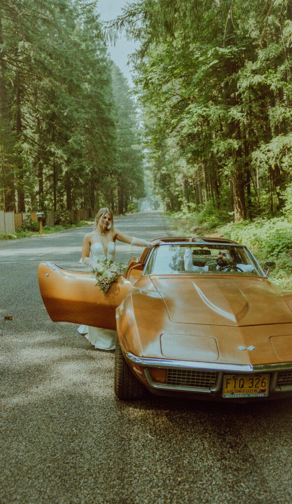 oregon bride and groom posing with a vintage car for their adventure elopement 