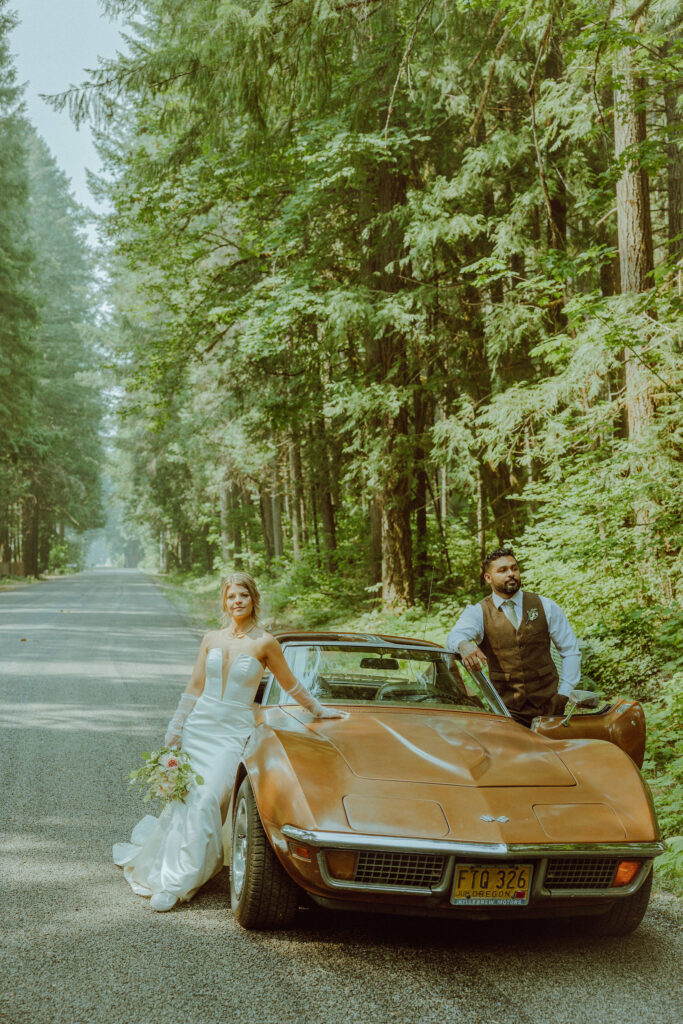 oregon bride and groom posing with a vintage car for their adventure elopement 