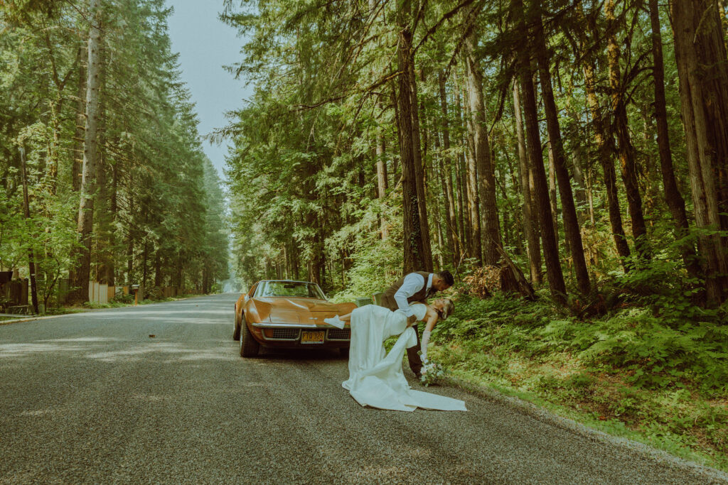 oregon bride and groom posing with a vintage car for their adventure elopement 