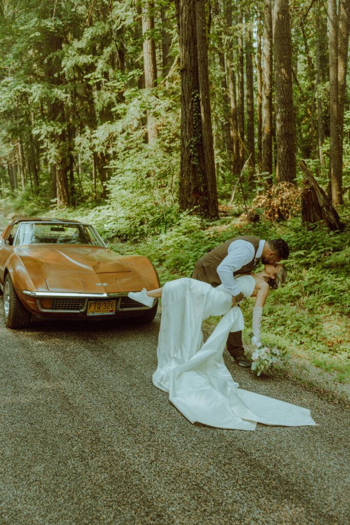 oregon bride and groom posing with a vintage car for their adventure elopement 