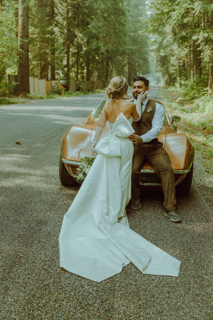 oregon bride and groom posing with a vintage car for their adventure elopement 