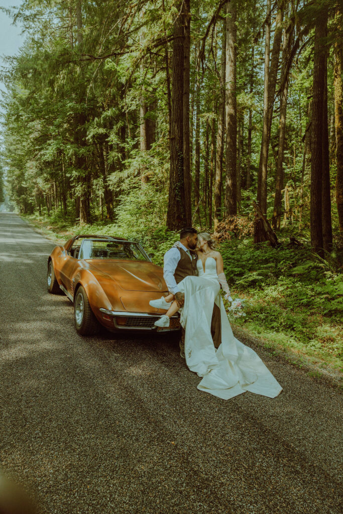 oregon bride and groom posing with a vintage car for their adventure elopement 