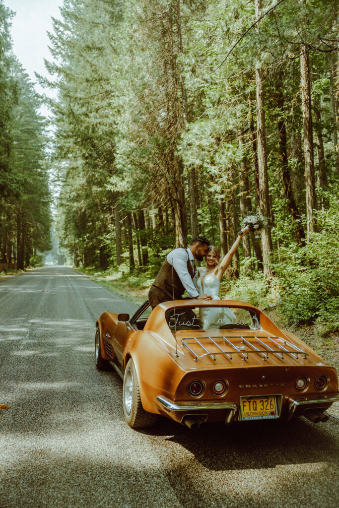 oregon bride and groom posing with a vintage car for their adventure elopement 