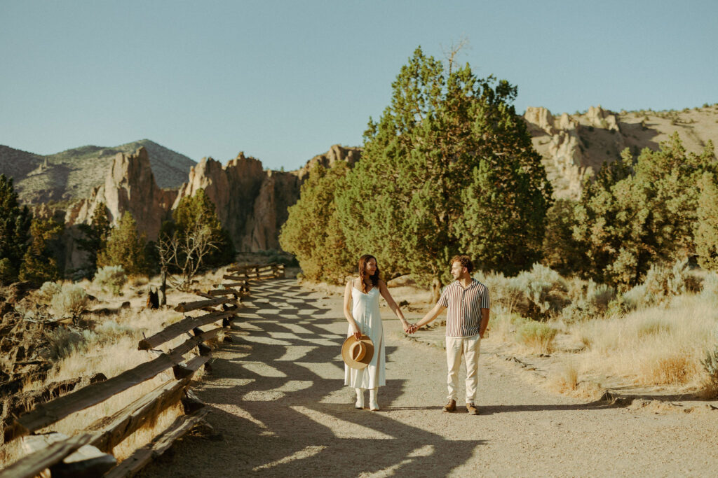couple holding hands for their engagement photos at smith rock state park in oregon