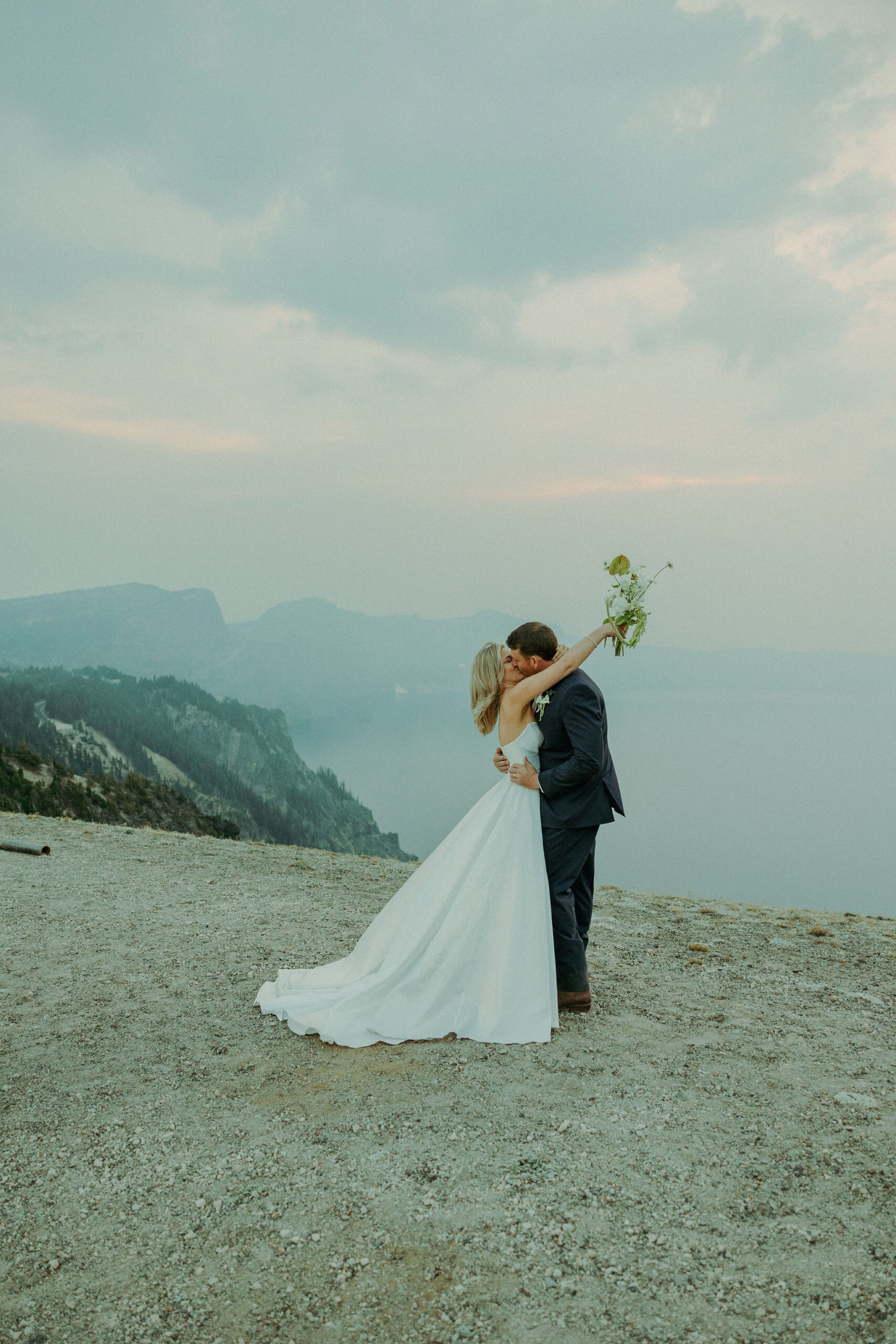 bride and groom kissing at destination elopement crater lake oregon