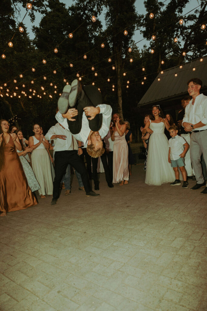 groom doing backflip on dance floor at wedding in oregon