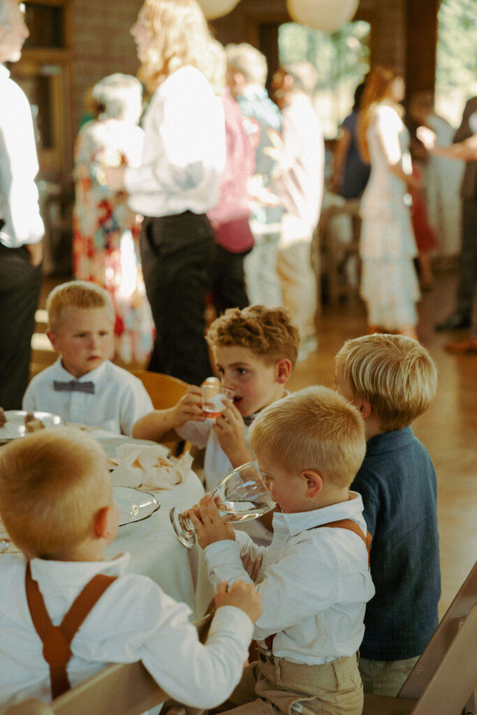 candid photo of kids eating dinner together at wedding 